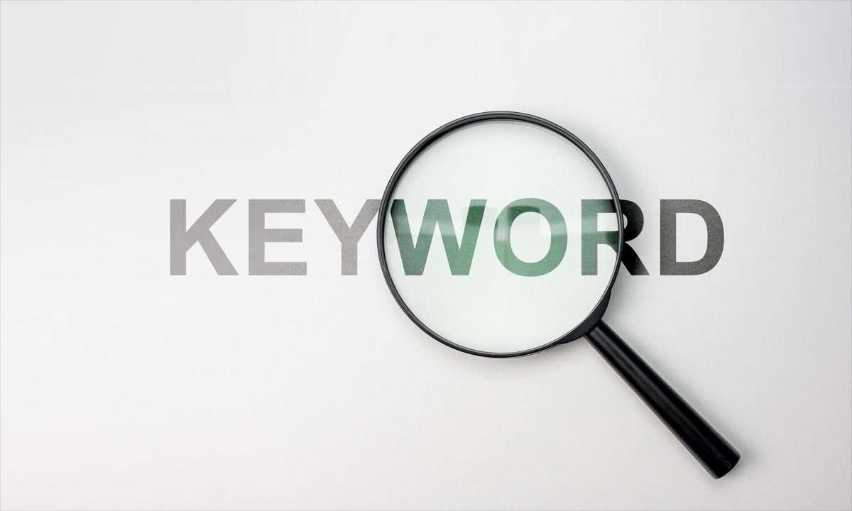 Lente di ingrandimento su parola keyword con sfondo bianco